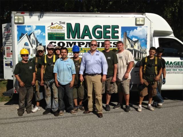 The Magee Roofing Company crew posing for a picture in front of their work truck